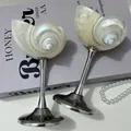 Pair of pearl seashell ornaments with silver metal stands on a purple book background - European Metal Conch Cup