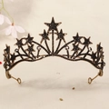 Detail view of vintage gold star crown with sparkling rhinestones on soft beige fabric - Vintage Gold/Star