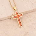 Detailed shot of golden cross necklace with orange and white cubic zirconia crystals - Orange