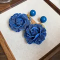 Elegant blue denim rose earrings with silver needles and beads on a display board - Silver Pin Denim Rose (Blue) / Blue