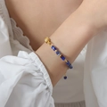 Elegante bracciale dorato con perline blu fantasia e accessori con nuvole di buon auspicio - Blu scuro