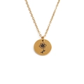 Detailed close-up of a golden circular pendant necklace featuring an engraved flower design - October