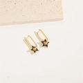 Detailopname van gouden rechthoekige oorbellen met zwarte emaille sterhangers - Zwart