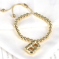 Detail of adjustable gold beaded bracelet featuring a sparkling zircon initial B pendant - Letter B