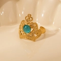 Macro shot of gold crown ring featuring a green cat's eye stone on a glossy surface - Green Cat's Eye-Gold