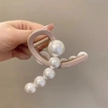 Dettaglio della pinza per capelli rosa con eleganti perle bianche e molla in metallo - Cachi