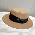 Detalle de sombrero de paja con cinta negra y logotipo M dorado de metal - Ajustable / Caqui