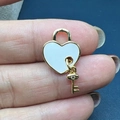 Macro shot of heart lock pendant with white enamel and a tiny gold key with zircon charm - Style D-Heart Lock Key