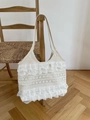Chique beige kanten draagtas met ruches en opengewerkte patronen aan houten stoel - Beige