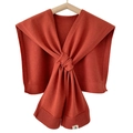 Chic brick red knitted scarf shawl with a knotted design on a wooden hanger - Orange Red