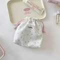 Détail d'un sac de rangement floral en toile avec motifs de fleurs bleues et cordon rose - Blanc