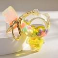 Detail of yellow floating bear keychain with colorful beads and liquid inside the shell - Gradient Strap + Bear / Lemon Yellow