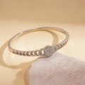 Primer plano detallado de brazalete plateado con cierre ovalado y circonitas finas - Plateado