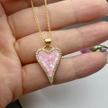 Pink shell heart necklace with gold finish and zircon stones shown in hand - Pink