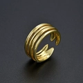 Dettaglio macro di un anello dorato multistrato regolabile con finitura in metallo lucido - Oro