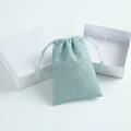 Light blue sequin drawstring jewelry pouch with two minimalist white gift boxes - Light Blue