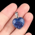 Pendentif coeur en lapis-lazuli bleu avec bélière argentée présenté sur un doigt - Lapis-lazuli