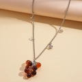 Détail du pendentif grappe de raisin avec perles en résine ambre sur chaîne argentée - Collier Raisin Marron