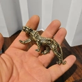 Dettaglio di una statuetta di leopardo in rame tenuta in mano con finitura in stile vintage - Leopardo