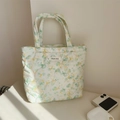 Detail of floral quilted cotton tote bag with a woven simple wish label on desk - Green Yellow Floral