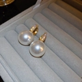 Macro detail of high-quality teardrop pearls and pavé cubic zirconia on gold hooks - White Pearl