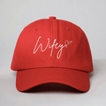 Detailed front view of red cotton baseball cap with white Wifey script and heart embroidery - Red