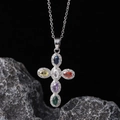 Silver cross necklace featuring multi-colored zircon stones on a dark textured rock - Silver Colorful Oval Gem Cross (款式17)