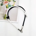 Detail of bicolor braided leather phone lanyard with metal clasps and decorative knot - Black+White