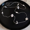 Gedetailleerde close-up van onregelmatige zilveren hangers aan een slangenketting - Zilver-Vierkant