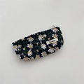 Detail of white daisy embroidery on black fabric pouch with woven brand tag and zipper - Pencil Case Black