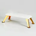Close-up of white leather manicure footrest with polished gold metal legs and non-slip pads - Pearl White (Sheet Metal Gold Legs)