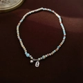 Détail du collier de perles en pierre naturelle bleue avec pendentif gravé en argent - Collier de perles porte-bonheur