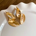 Orecchini a foglia irregolare dorati su un piatto di ceramica bianca con sfondo in legno scuro - Forma a Foglia Torta Irregolare / Oro (Perno in Argento S925)