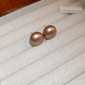 Lustrous brown spherical pearl stud earrings with gold pins on a beige cushion - Gold Plated Matte Coffee