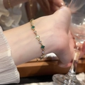Detalle de pulsera dorada con tréboles verdes y gemas brillantes de circonita cúbica - 3# Pulsera Trébol Verde (Chapado en Oro Real)