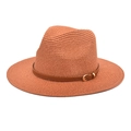 Detail of rust red straw fedora hat featuring a brown leather band and gold metal buckle - Caramel color