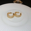 Detalle de aros dorados retorcidos con textura de múltiples hilos en un plato - 6# Estilo Envuelto en Alambre / Pin de Plata Pendientes de Botón en Forma de C