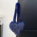 Close-up detail of dark blue heart-shaped faux fur bag with soft fluffy plush texture - Sapphire Blue