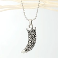 Detail of vintage wolf tooth pendant with embossed patterns on silver bead chain - Antique Silver Metal Fang