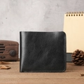 Detailed view of a black crazy horse leather wallet on a rustic wooden tabletop - Black