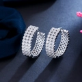 Elegant silver hoop earrings with shimmering cubic zirconia on black reflective surface - White Gold