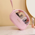 Pink PU leather toiletry bag with clear window and handle on a vanity table - Medium / Pink