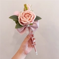 Dettaglio di una penna con rosa di seta rosa tenuta in mano con fiocco e perla - Rosa Imperiale con Fiocco / Rosa