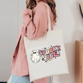 Detail of white canvas tote bag featuring spooky vibes ghost print worn with pink shirt - Spooky Vibes (Rainbow)