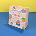 Bolsa de regalo rosa con diseño de fresas y asa blanca sobre fondo colorido - 14x15x7cm / Fresa