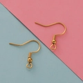 Vista macro de ganchos dorados de acero para pendientes con muelle y bola para joyería DIY - Dorado