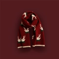 Close-up of red Christmas knitted scarf with reindeer and snowflake patterns - Antler Red