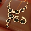Vintage Schmuckset mit ovalen schwarzen Edelsteinen und eleganten goldenen Spiral-Details - Gold-Schwarz Wirbel Stil
