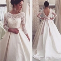 Elegante witte kanten trouwjurk met lange mouwen en open rug met roze satijnen strik - US maat 2 (S) / Ivoor