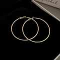 Makroaufnahme goldener minimalistischer Creolen auf einer schwarzen Samtschmuckschatulle - 6cm / Gold